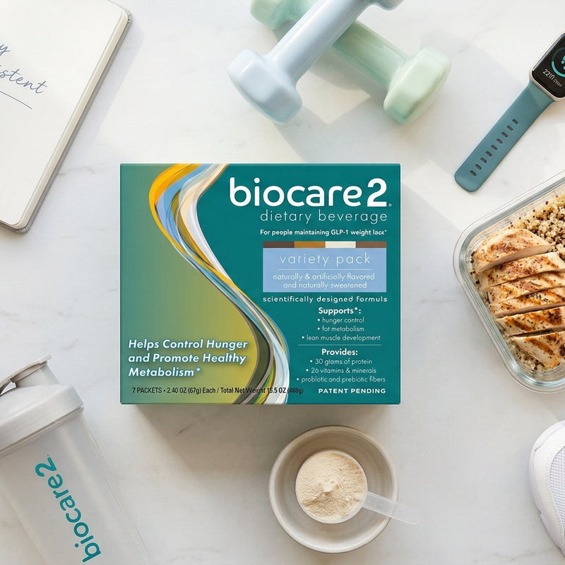 Biocare2 supplement box with a meal container, water bottle, and other health-related items on a white surface.